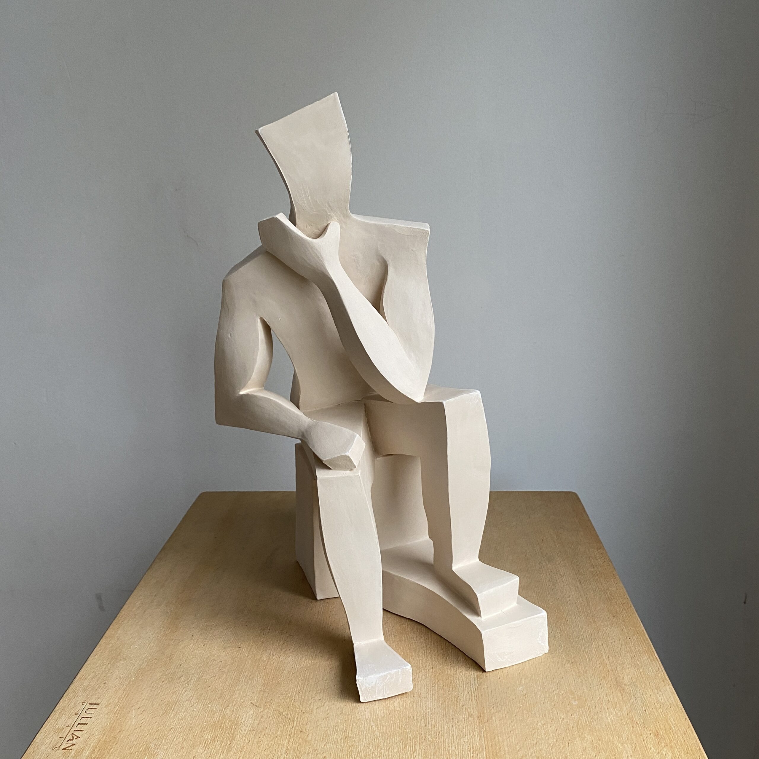 Sculpture cubiste homme assis avec la main sur le visage